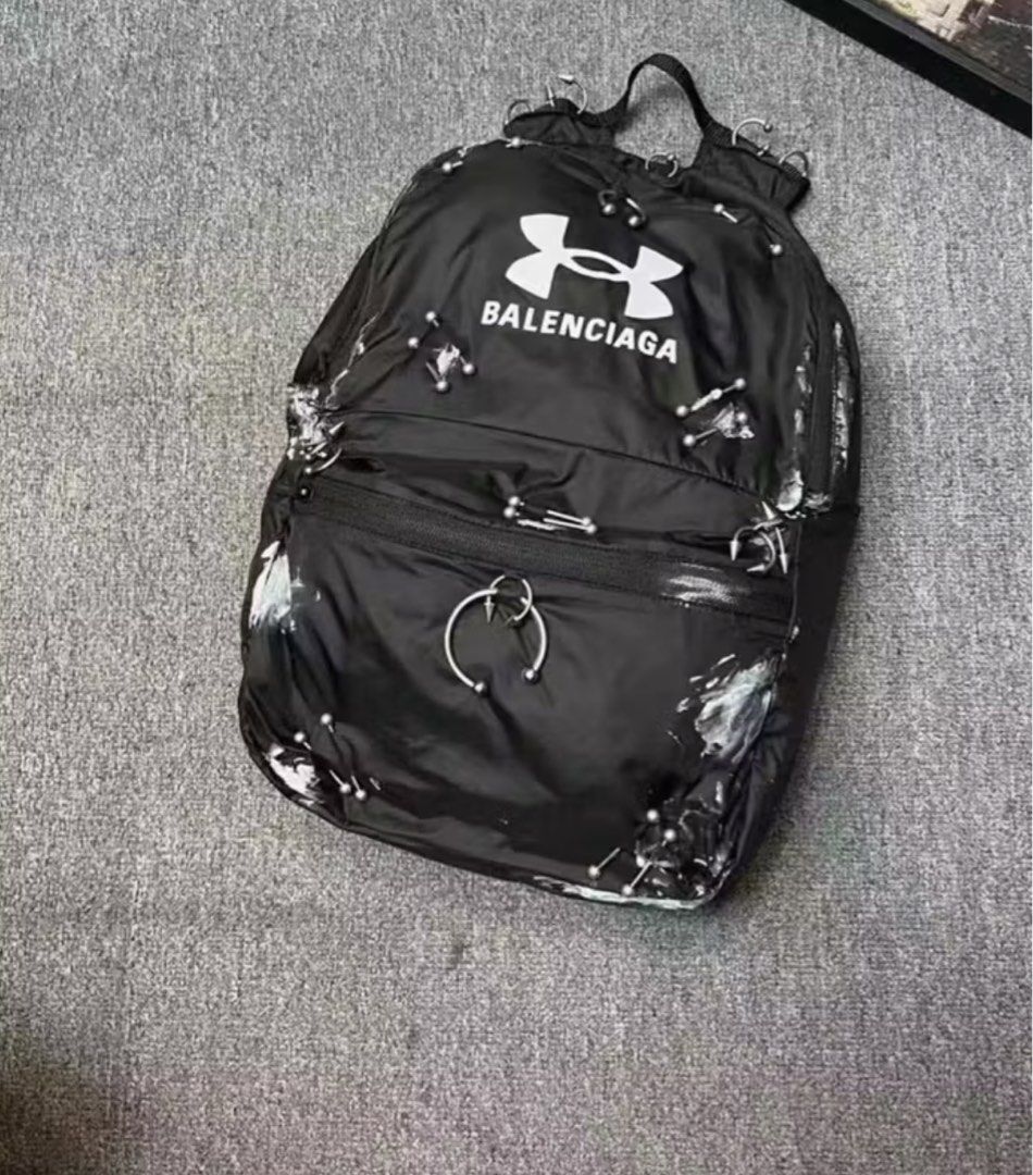 Under Armour Balenciaga Backpack (Category: Luxury Bags & Wallets) located in Calamba. Submitted by apppp_117 (Listing ID 1410545994, Image 1). Description: - Black backpack with Under Armour and Balenciaga logos. - Front zippered pocket. - Top handle. - Adjustable shoulder straps. - Main compartment. - Interior label: "Under Armour" and "Made in Italy". i cant provide more pics the shipping is about 10-17 days so please be patient thank you!!.