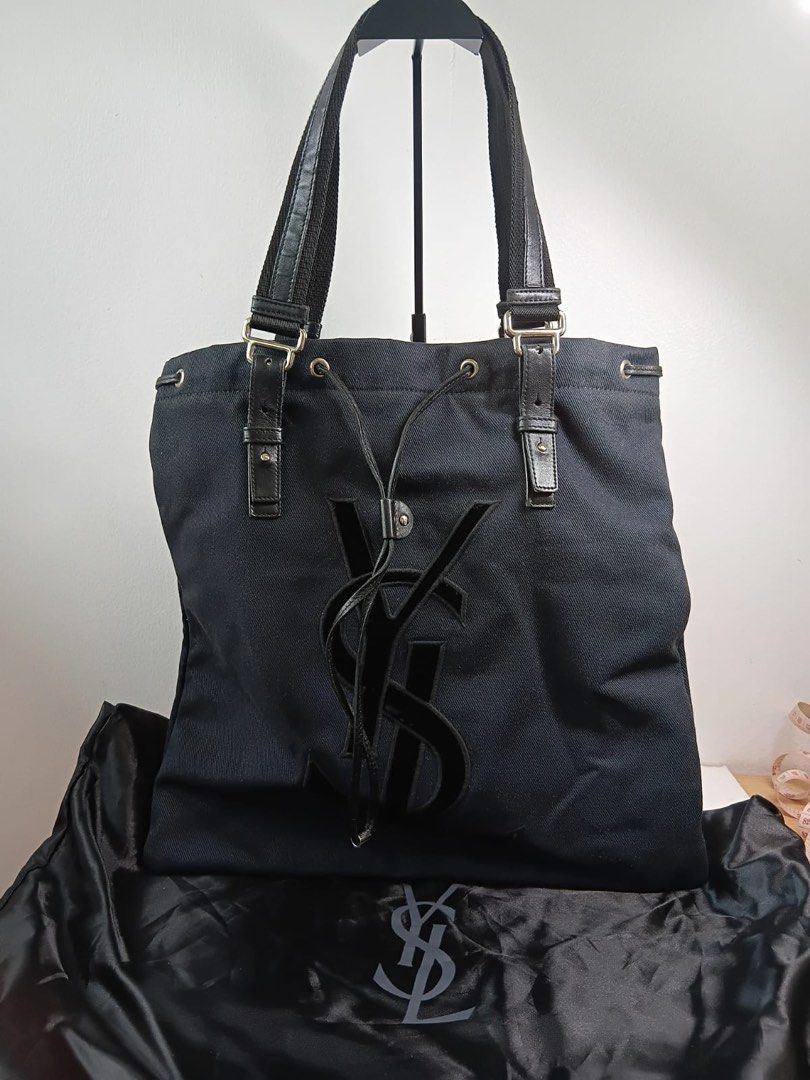 YSL Black Tote Bag (Category: Luxury Bags & Wallets) located in Makati City. Submitted by ajoloso_69 (Listing ID 1410535259, Image 1). Description: - Authentic YSL black tote bag - Features the classic YSL logo - Equipped with two top handles - Secure drawstring closure - Includes original YSL dust bag - Crafted from a durable, canvas-like material.