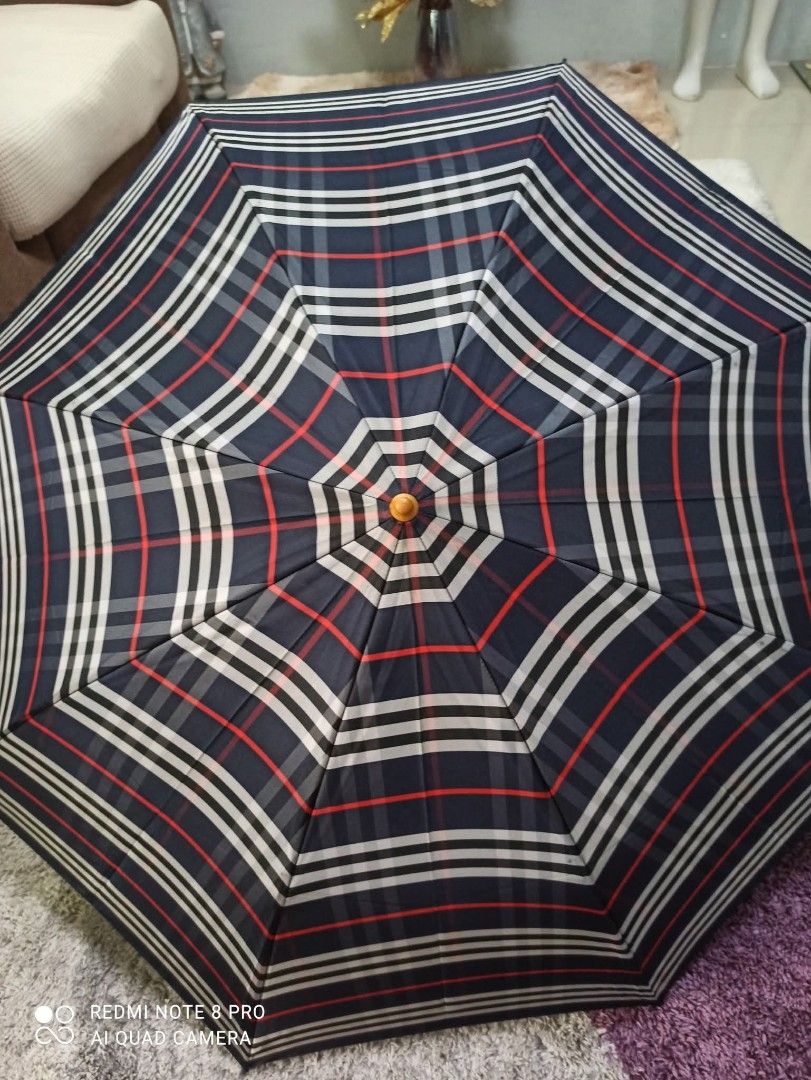 Burberry Checkered Umbrella (Category: Umbrellas) located in Danao, Cebu. Submitted by anne_2016143 (Listing ID 1410685244, Image 3). Description: - Authentic Burberry umbrella - Signature checkered pattern - Wooden handle - Leather strap - Burberry logo detail.