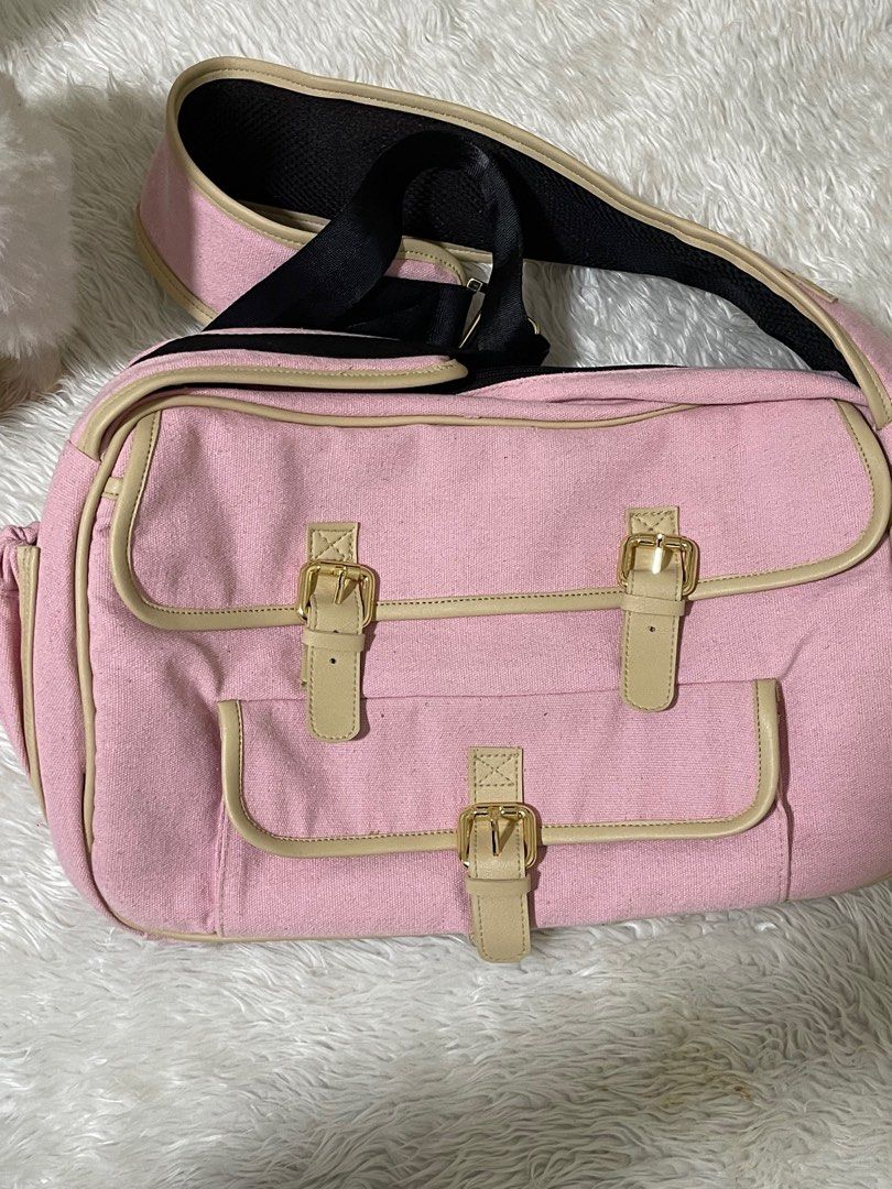 Dog bag/Dog carrier (Category: Homes & Other Pet Accessories) located in Manila. Submitted by loveditemsbyj (Listing ID 1410608832, Image 1). Description: - Pink shoulder bag - Beige accents - Gold-colored buckles - Long, adjustable strap with black mesh for comfort - Multiple compartments - Two front pockets - Zippered main compartment - Black interior lining.