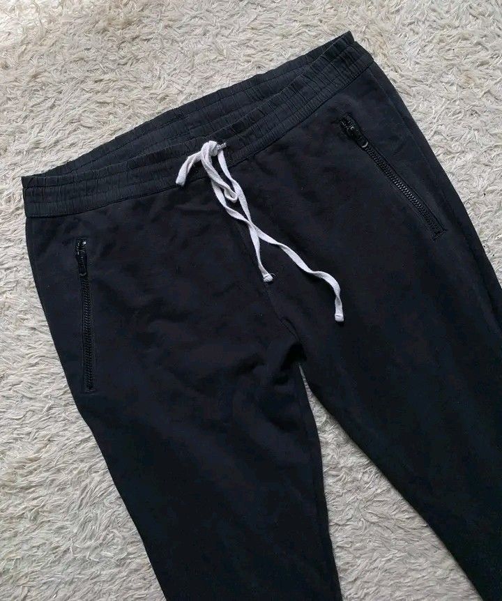 Fear of God Essentials Sweatpants (Category: Joggers) located in Butuan. Submitted by markystuffs23 (Listing ID 1410699452, Image 2). Description: - Fear of God Essentials Sweatpants - Color: Black - Features: - Drawstring waist - Zippered pockets - Two back pockets - Measurements (approximate): - Waistband: 16 inches - Inseam: 37 inches - Material: Soft and comfortable - Authentic Essentials tag visible.