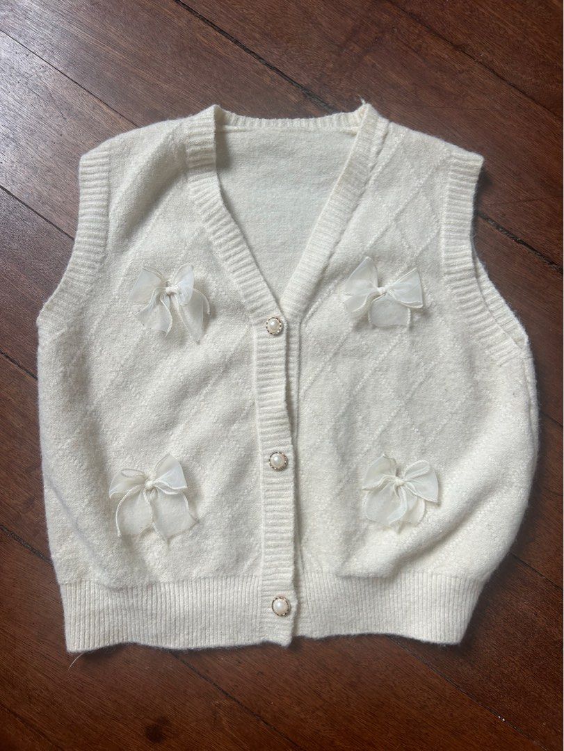 Premium Knitted Vest Classy Chic Coquette Bow Oversized (Category: Sleeveless) located in Quezon City. Submitted by theukayera (Listing ID 1410606260, Image 1). Description: Old money coded! Chic Parisian vibes Knitted vest with no runs and complete buttons. Laid flat measurements: Length: 20” Pit to pit: 19” (Free size, can fit XL) Arm hole: 8” On hand and ready to ship! 📍near Commonwealth, QC.