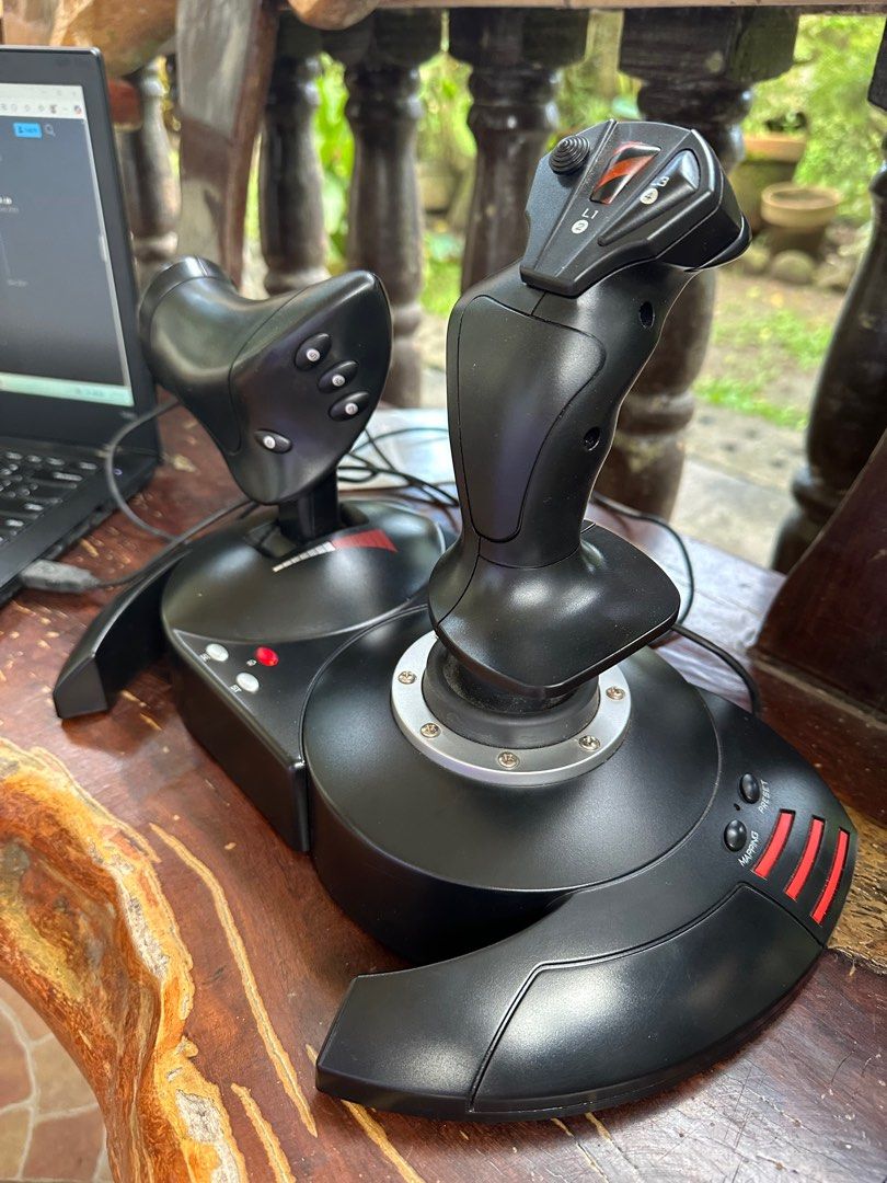Thrustmaster t.flight Hotas X (Category: Controllers) located in Liliw. Submitted by luthersuerte (Listing ID 1410625111, Image 2). Description: - Thrustmaster T.Flight Hotas X joystick - Detachable throttle and joystick - Multiple buttons for control - POV hat switch - Rubber feet for stability - Cable storage compartment - Stylish black design with red accents.