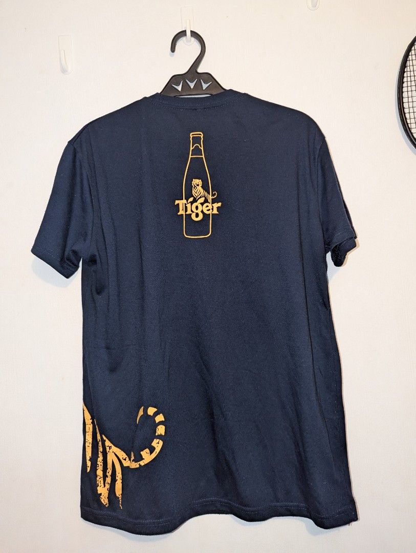 Tiger Beer Graphic T-Shirt (only) (Category: Tshirts & Polo Shirts ) located in Porac. Submitted by themightythrift (Listing ID 1410630102, Image 3). Description: - Navy blue Tiger Beer t-shirt: - Features a tiger graphic on the front. - Includes a beer bottle graphic with the Tiger Beer logo on the back. - Crew neck style. .