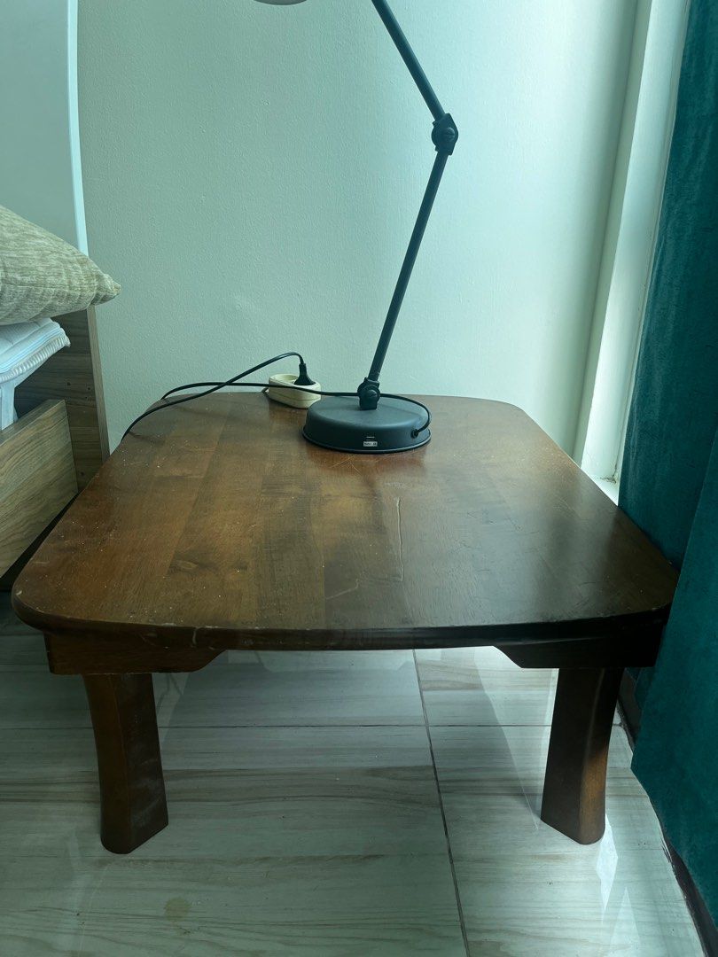 Wooden Coffee Table (Category: Tables & Sets) located in Pasay City. Submitted by beye01 (Listing ID 1410698480, Image 3). Description: - Rectangular wooden coffee table with rounded corners. - Warm brown finish. - Dimensions: 750mm wide x 600mm deep x 300mm high. - Made of natural wood with urethane resin coating. - Avoid direct sunlight and heat. - Do not place heated pots or use strong detergents. Lamp sold separately. Table legs can be folded