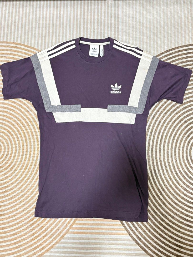 Adidas Retro T-shirt (Category: Tshirts & Polo Shirts ) located in Quezon City. Submitted by prelovedfits1 (Listing ID 1407456698, Image 1). Description: - Adidas retro t-shirt - Purple base color - White and grey accents - Adidas logo on the chest - Short sleeves - Crew neck - Solid purple back.