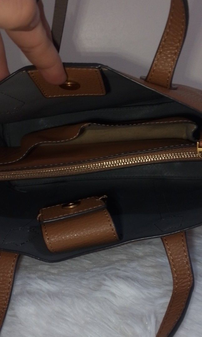Brown Leather Handbag (Category: Luxury Bags & Wallets) located in Bacolor. Submitted by pinktintmine (Listing ID 1407438127, Image 2). Description: - Brown leather exterior - Structured design - Top handle - Magnetic closure - Interior zippered compartment - Additional pockets - Contrasting interior color - Visible stitching on handles.