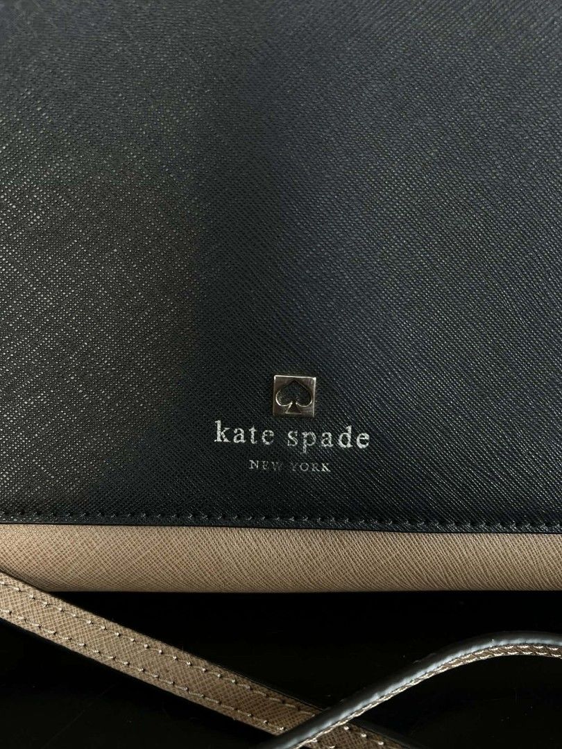 Kate Spade Two-Tone Crossbody Bag (Category: Cross-body Bags) located in Quezon City. Submitted by peralnorie53313 (Listing ID 1407395324, Image 3). Description: Kate Spade crossbody bag in a two-tone design. Features a navy blue flap and a tan body. Includes a chain strap and a Kate Spade logo on the front. The interior has a fabric lining with the Kate Spade logo pattern. The bag has a small stain on the side. Made in China,minimal fade on logo