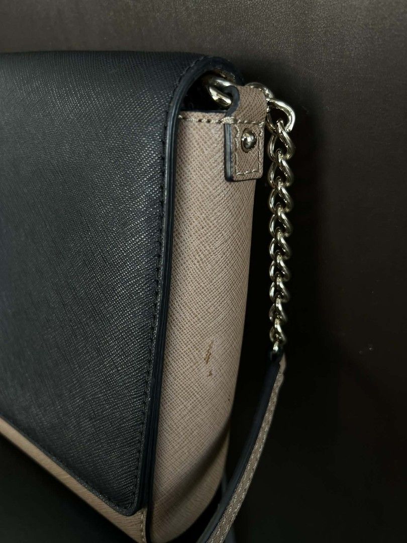 Kate Spade Two-Tone Crossbody Bag (Category: Cross-body Bags) located in Quezon City. Submitted by peralnorie53313 (Listing ID 1407395324, Image 2). Description: Kate Spade crossbody bag in a two-tone design. Features a navy blue flap and a tan body. Includes a chain strap and a Kate Spade logo on the front. The interior has a fabric lining with the Kate Spade logo pattern. The bag has a small stain on the side. Made in China,minimal fade on logo