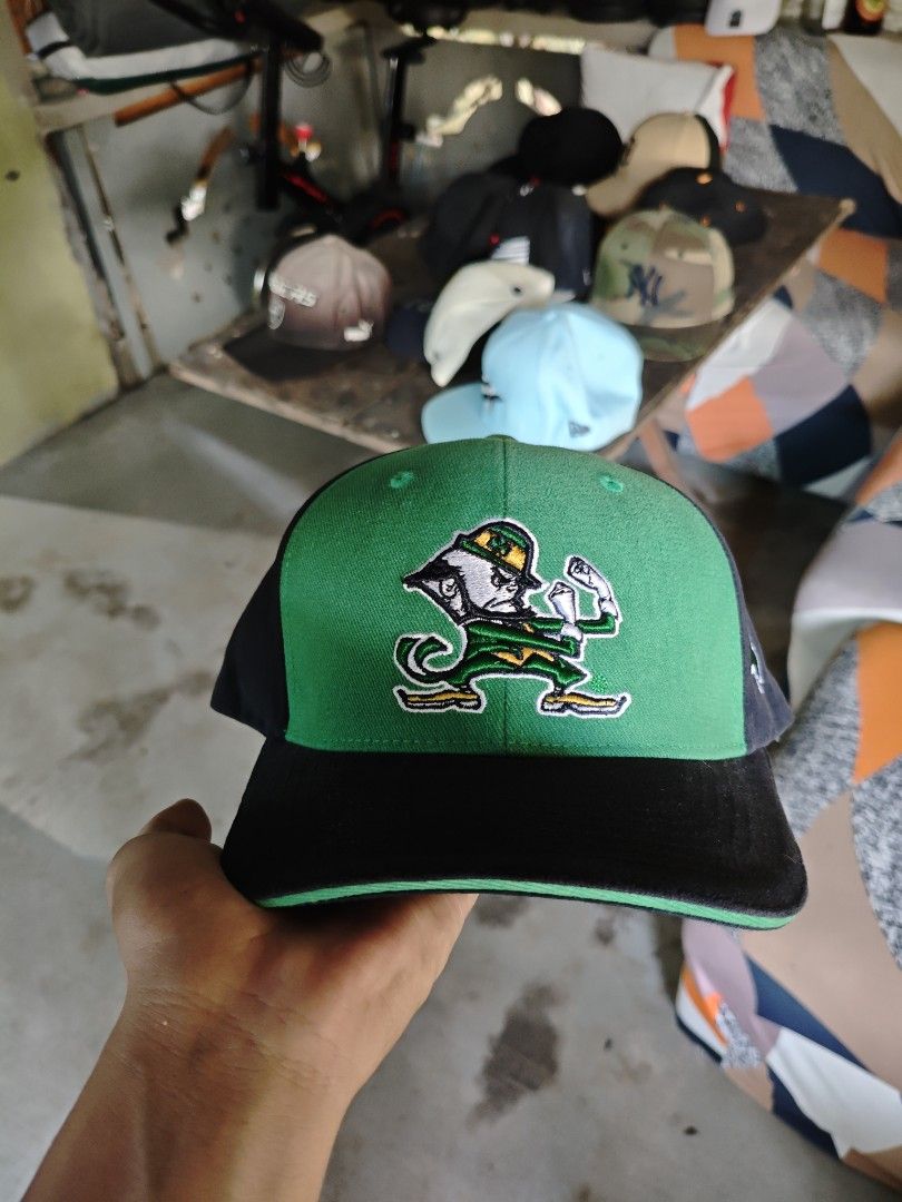 Notre Dame Irish Cap (Category: Caps & Hats) located in San Jose del Monte. Submitted by authenticeraph (Listing ID 1407448464, Image 2). Description: - Notre Dame Irish cap - Features the Notre Dame logo - Green and black color scheme - Shamrock detail on the side - Adjustable strap with "IRISH" text - "Captivating" tag inside.