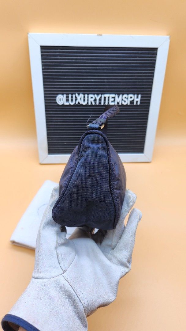 Prada Navy Nylon Baguette Bag (Category: Luxury Bags & Wallets) located in Pamplona. Submitted by luxuryitems_ph (Listing ID 1407501230, Image 2). Description: - Prada baguette bag - Features iconic triangular Prada logo - Interior includes Prada logo and "Made in Italy" tag - Secure zipper closure - Comes with dust bag Issue 9th pic discoloration(not obvious) 10th pic needs restitch.