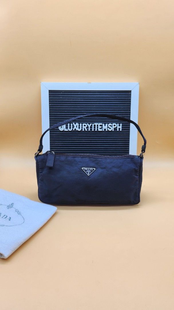 Prada Navy Nylon Baguette Bag (Category: Luxury Bags & Wallets) located in Pamplona. Submitted by luxuryitems_ph (Listing ID 1407501230, Image 1). Description: - Prada baguette bag - Features iconic triangular Prada logo - Interior includes Prada logo and "Made in Italy" tag - Secure zipper closure - Comes with dust bag Issue 9th pic discoloration(not obvious) 10th pic needs restitch.