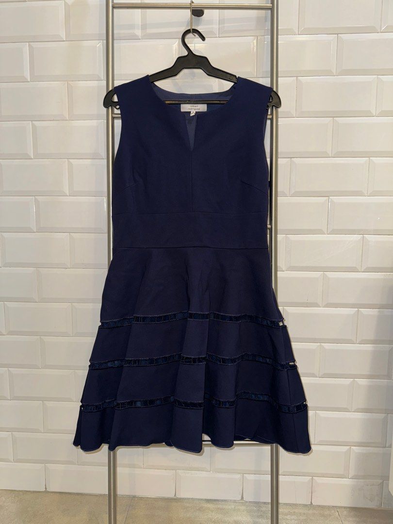 Robert Rodriguez Navy Office Dress Size 8 (Category: Dresses) located in Mandaluyong City. Submitted by wpitw (Listing ID 1407412154, Image 1). Description: Elegant navy dress by Robert Rodriguez. Features a V-neckline and a tiered skirt design with dark navy ribbon detailing. The dress is sleeveless and has a fitted bodice that flows into a flared skirt. Size 8..