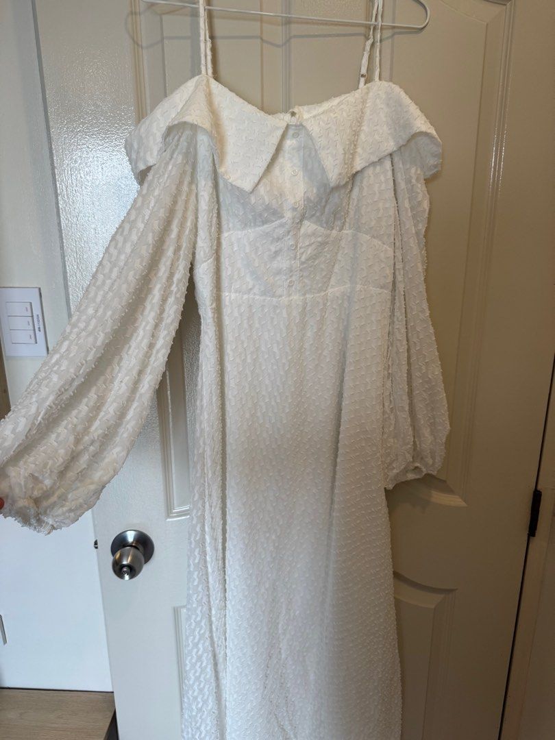 Shein Off-Shoulder White Dress (Category: Dresses) located in Cavite. Submitted by cielinesid (Listing ID 1407562522, Image 2). Description: Elegant white dress from Shein. Features an off-shoulder design with spaghetti straps and long, puffy sleeves. The dress has a textured fabric and a flattering A-line silhouette. It includes a collar detail and a fitted waist. Size is Large, with a 40-inch bust and a 31.5-inch waist..