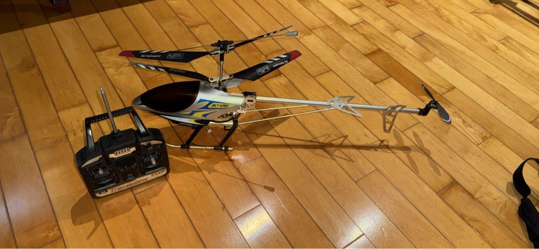 Sky King RC Helicopter with Transmitter (Category: Remote Control Toys) located in Manila. Submitted by fearlesscontender (Listing ID 1407558093, Image 1). Description: - Sky King RC Helicopter - Includes transmitter - Features main and tail rotors - Sleek black, silver, and yellow design.