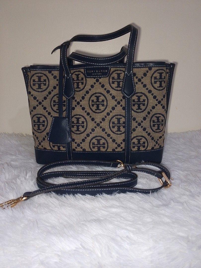 Tory Burch Tote Bag with Strap (Category: Luxury Bags & Wallets) located in Bacolor. Submitted by pinktintmine (Listing ID 1407437248, Image 1). Description: - Tory Burch tote bag - Detachable strap - Beige and black pattern - Tory Burch logo - Black handles and trim - White stitching - Gold-colored hardware - Includes small leather tag.