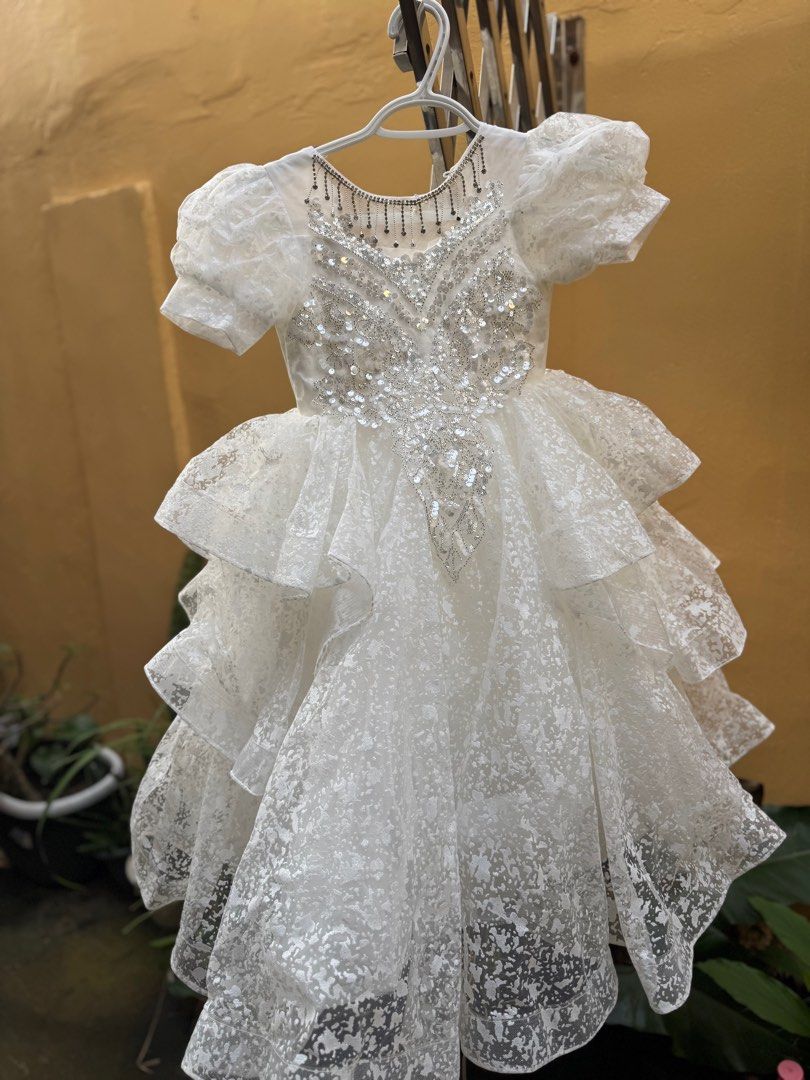White Party Dress - Size 110 (Category: Babies & Kids Fashion) located in Cavite. Submitted by burayyy (Listing ID 1407563938, Image 2). Description: - White party dress - Size 110 - Layered skirt - Embellished bodice - Short, puffy sleeves - Lace-up back for adjustable fit - Delicate, textured overlay - Perfect for special occasions good condition. only worn once. my kid outgrown it. perfect for formal occassions please arrange your own pick up.