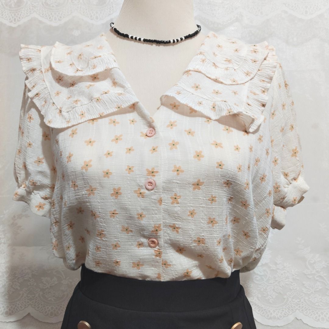 Beige Floral Ruffle Collar Button Down Blouse with Puff Sleeve (Category: Blouses) located in Mandaluyong City. Submitted by princesspockets (Listing ID 1410849045, Image 3). Description: Perfect for Korean-style office or casual look! Comes with double layers of ruffled collar and puff sleeves. Best fit: S-M 🌸 FLAT LAY MEASUREMENTS 🌸 Bust: 36 in Length: 23 in 🌸 REMINDERS 🌸 - Thrifted / Preloved / Ukay, lightly washed. PLEASE MANAGE YOUR EXPE