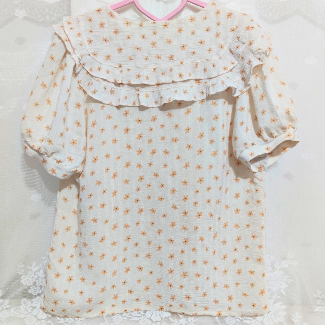 Beige Floral Ruffle Collar Button Down Blouse with Puff Sleeve (Category: Blouses) located in Mandaluyong City. Submitted by princesspockets (Listing ID 1410849045, Image 2). Description: Perfect for Korean-style office or casual look! Comes with double layers of ruffled collar and puff sleeves. Best fit: S-M 🌸 FLAT LAY MEASUREMENTS 🌸 Bust: 36 in Length: 23 in 🌸 REMINDERS 🌸 - Thrifted / Preloved / Ukay, lightly washed. PLEASE MANAGE YOUR EXPE
