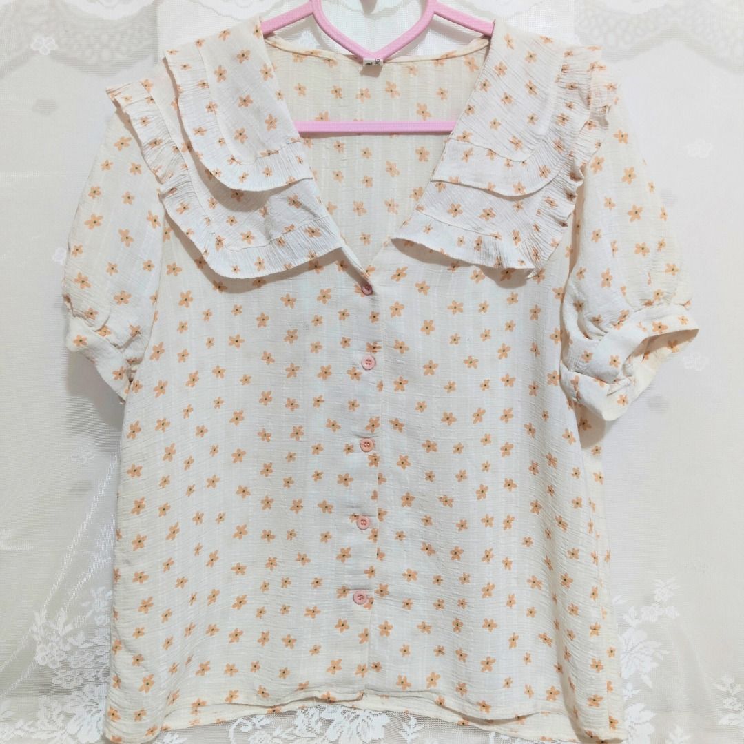 Beige Floral Ruffle Collar Button Down Blouse with Puff Sleeve (Category: Blouses) located in Mandaluyong City. Submitted by princesspockets (Listing ID 1410849045, Image 1). Description: Perfect for Korean-style office or casual look! Comes with double layers of ruffled collar and puff sleeves. Best fit: S-M 🌸 FLAT LAY MEASUREMENTS 🌸 Bust: 36 in Length: 23 in 🌸 REMINDERS 🌸 - Thrifted / Preloved / Ukay, lightly washed. PLEASE MANAGE YOUR EXPE