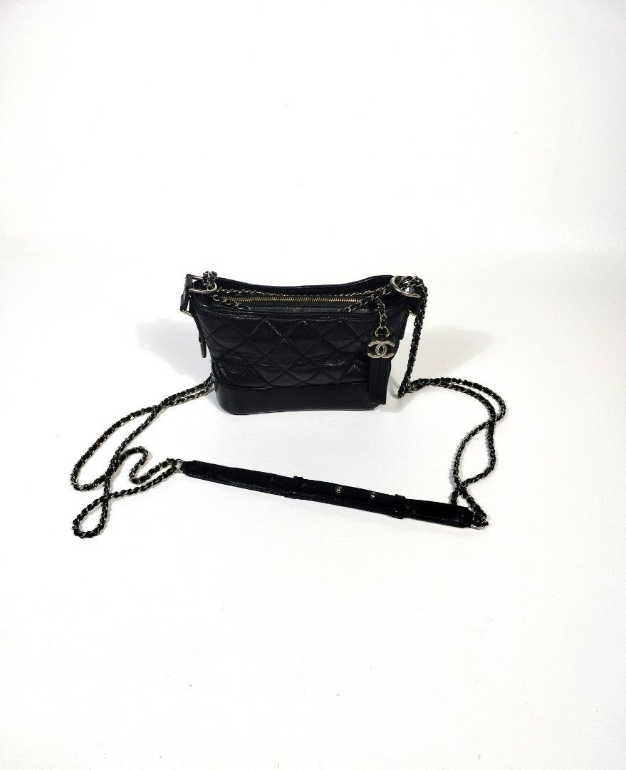 Chanel Gabrielle Mini Hobo Bag Black (Category: Luxury Bags & Wallets) located in Manila. Submitted by callmetin (Listing ID 1410814719, Image 1). Description: Chanel Gabrielle Hobo bag in black. Features a quilted design with a chain strap and a detachable leather strap. Includes a zipper closure and a Chanel logo charm. The interior is lined with pink fabric and includes a serial number tag. Made in Italy..