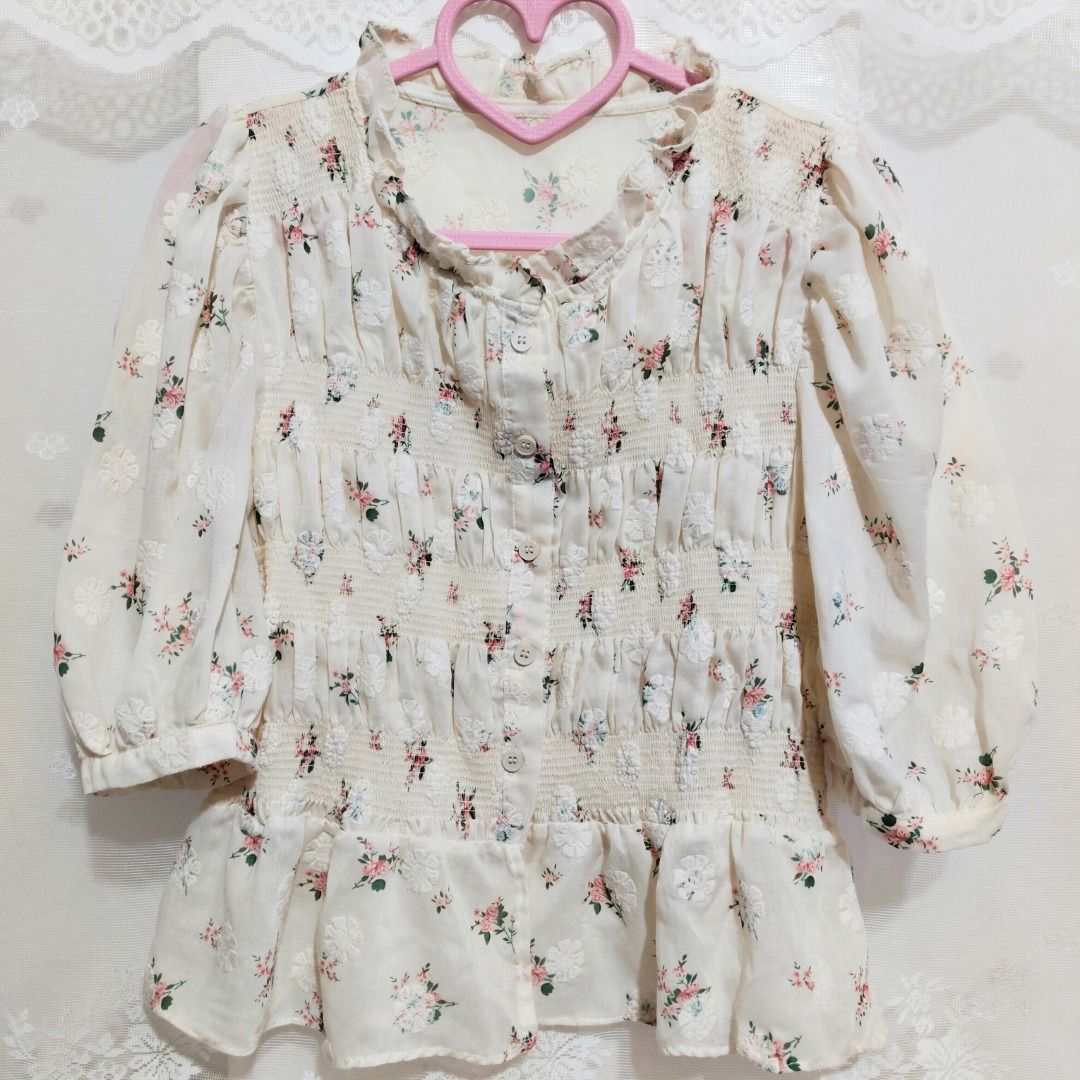 Cream Smocked Floral Button Down Peplum Blouse (Category: Blouses) located in Mandaluyong City. Submitted by princesspockets (Listing ID 1410861479, Image 1). Description: Premium top! The bodice has multiple smocking and working buttons. Features a ruffled mock neck and puff sleeves. Best fit: M-XL 🌸 FLAT LAY MEASUREMENTS 🌸 Bust: 32-40 in Length: 20 in 🌸 REMINDERS 🌸 - Thrifted / Preloved / Ukay, lightly washed. PLEASE MANAGE YOUR EXPECTATION