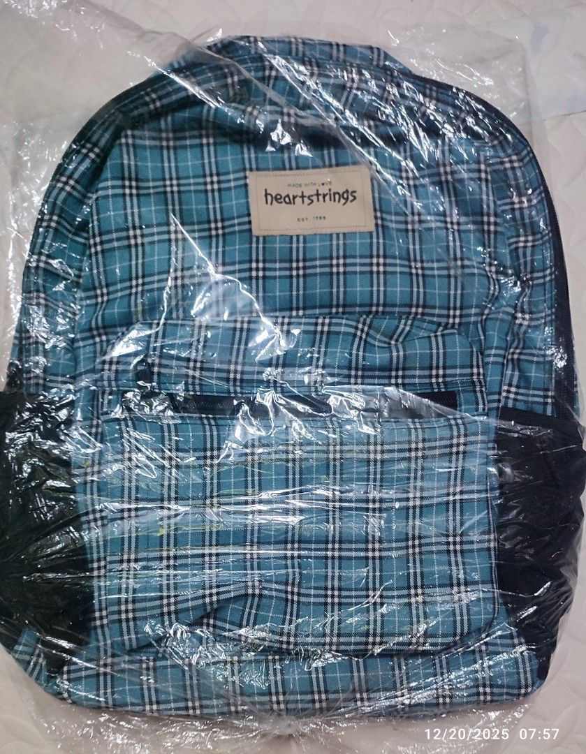 Heartstrings Plaid Backpack Checkered Blue (Category: Backpacks) located in Quezon City. Submitted by gemaicloset (Listing ID 1410720253, Image 1). Description: Heartstrings backpack features a blue plaid pattern. The backpack is designed with a classic style, suitable for everyday use. The brand name is visible on a tag on the front of the bag..
