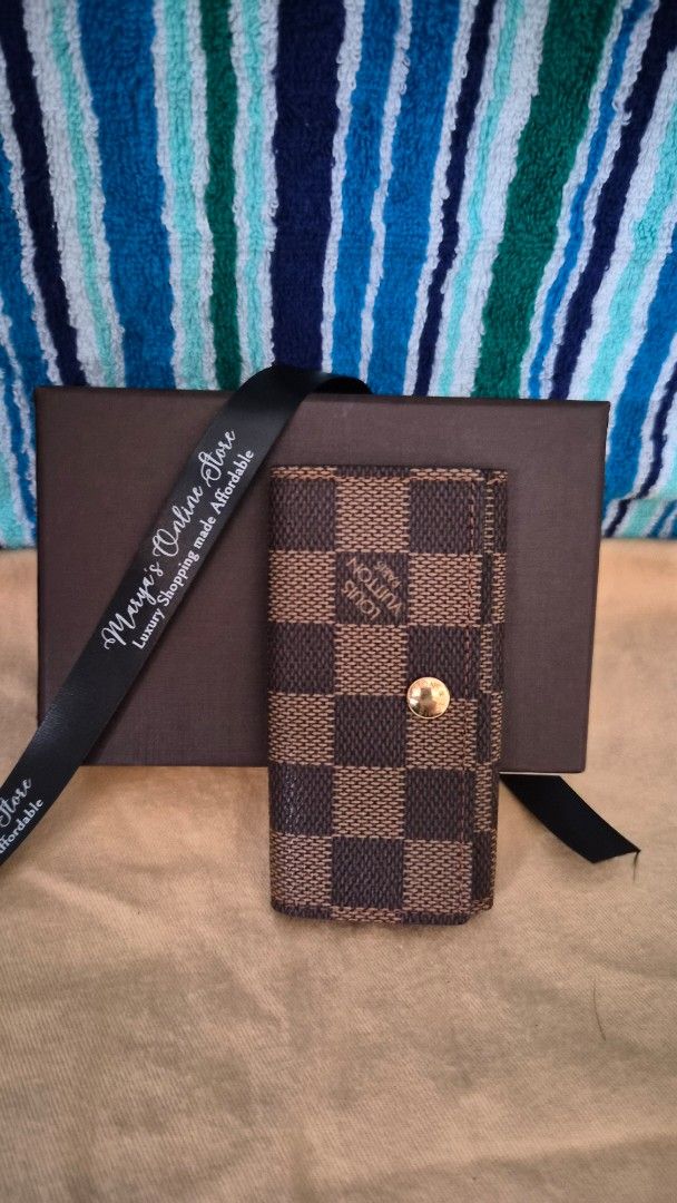 Louis Vuitton Damier Ebene Key Holder (Category: Luxury Bags & Wallets) located in Quezon City. Submitted by marya_s (Listing ID 1410764848, Image 2). Description: - Authentic Louis Vuitton key holder - Damier Ebene canvas - Snap closure - Gold-tone hardware - Brown leather lining - Includes key rings - Comes with original box and ribbon - Stylish and practical.