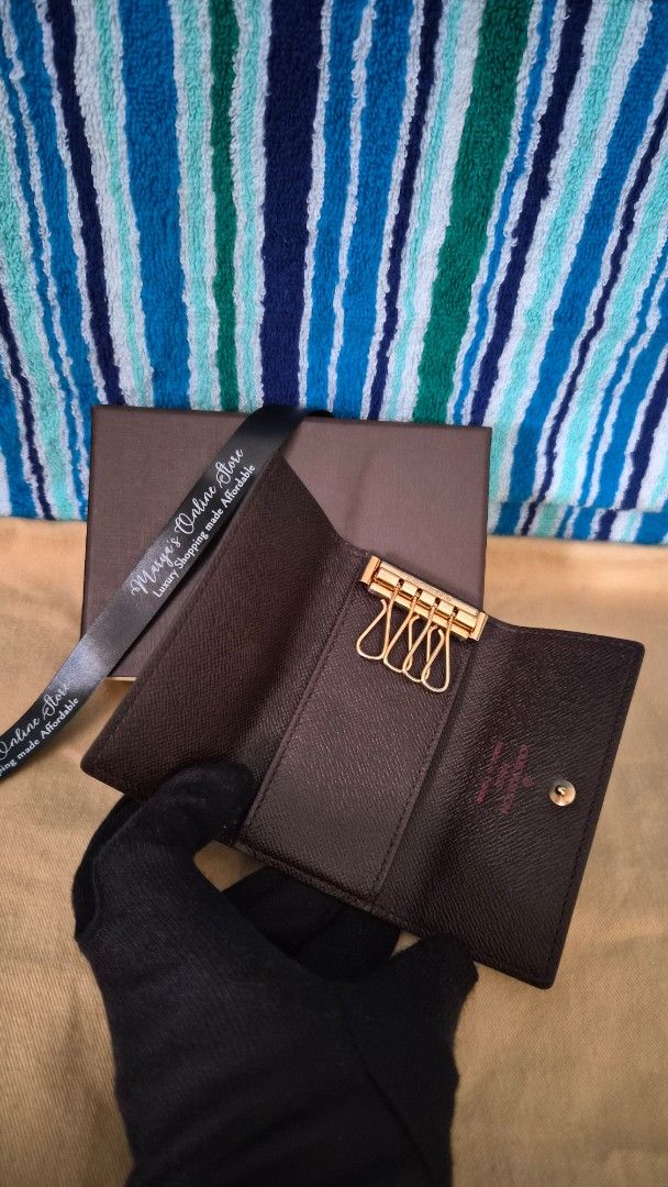 Louis Vuitton Damier Ebene Key Holder (Category: Luxury Bags & Wallets) located in Quezon City. Submitted by marya_s (Listing ID 1410764848, Image 3). Description: - Authentic Louis Vuitton key holder - Damier Ebene canvas - Snap closure - Gold-tone hardware - Brown leather lining - Includes key rings - Comes with original box and ribbon - Stylish and practical.