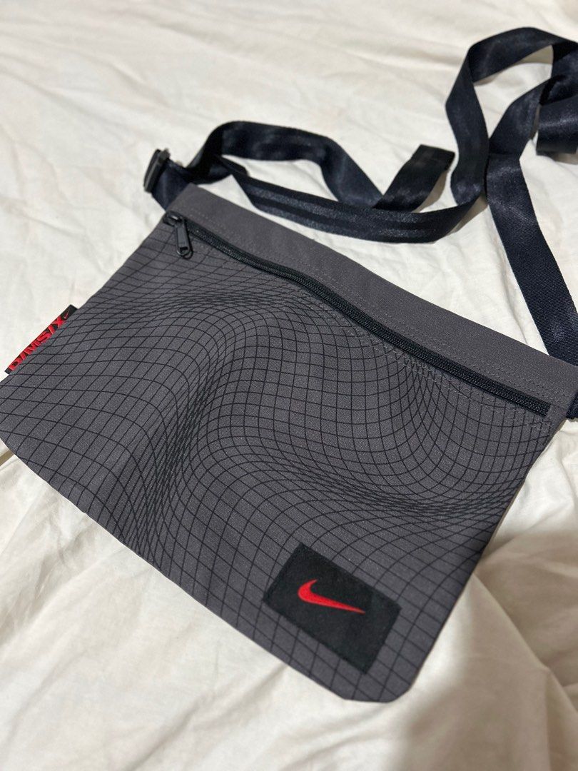 Nike Small Sling Bag (Category: Sling Bags) located in Manila. Submitted by bodegabodega (Listing ID 1410765764, Image 1). Description: - Gray Nike sling bag with black strap - Zippered main compartment - Small Nike logo on the front - Unique wavy grid pattern - Adjustable strap - Stylish and practical design.