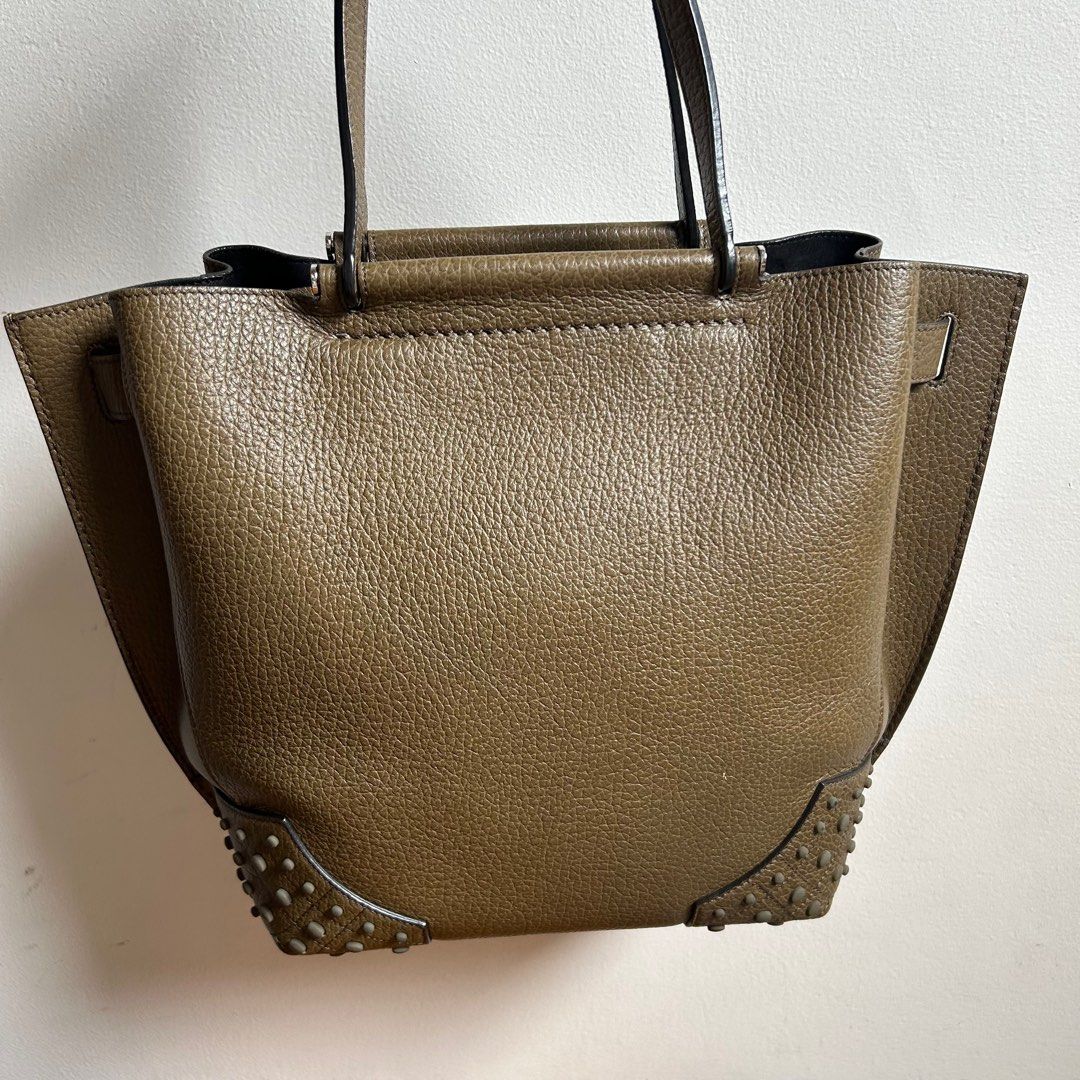 Authentic TOD'S Wave Shopping Tote Leather Handbag (Category: Luxury Bags & Wallets) located in Pasig City. Submitted by closet4hope (Listing ID 1410740185, Image 2). Description: Top handle bag but can also be worn over the shoulder Olive green color with structured design and protective studs on base Cowhide leather with inner zipper pocket and metal magnetic closures Made in Italy Only one scratch as shown in picture and hardly visible when yo