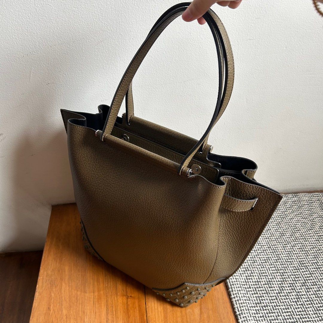 Authentic TOD'S Wave Shopping Tote Leather Handbag (Category: Luxury Bags & Wallets) located in Pasig City. Submitted by closet4hope (Listing ID 1410740185, Image 3). Description: Top handle bag but can also be worn over the shoulder Olive green color with structured design and protective studs on base Cowhide leather with inner zipper pocket and metal magnetic closures Made in Italy Only one scratch as shown in picture and hardly visible when yo
