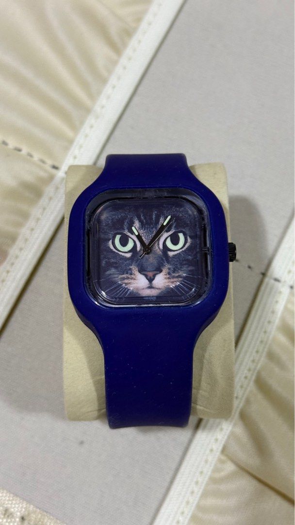 Tomato Swap Cat Face Watch (Category: Men's Watches) located in Manila. Submitted by lbiliran1346900 (Listing ID 1410736652, Image 1). Description: - Cat face dial design - Blue silicone strap - Black buckle - Brand: "Swap" - Material: Silicone.