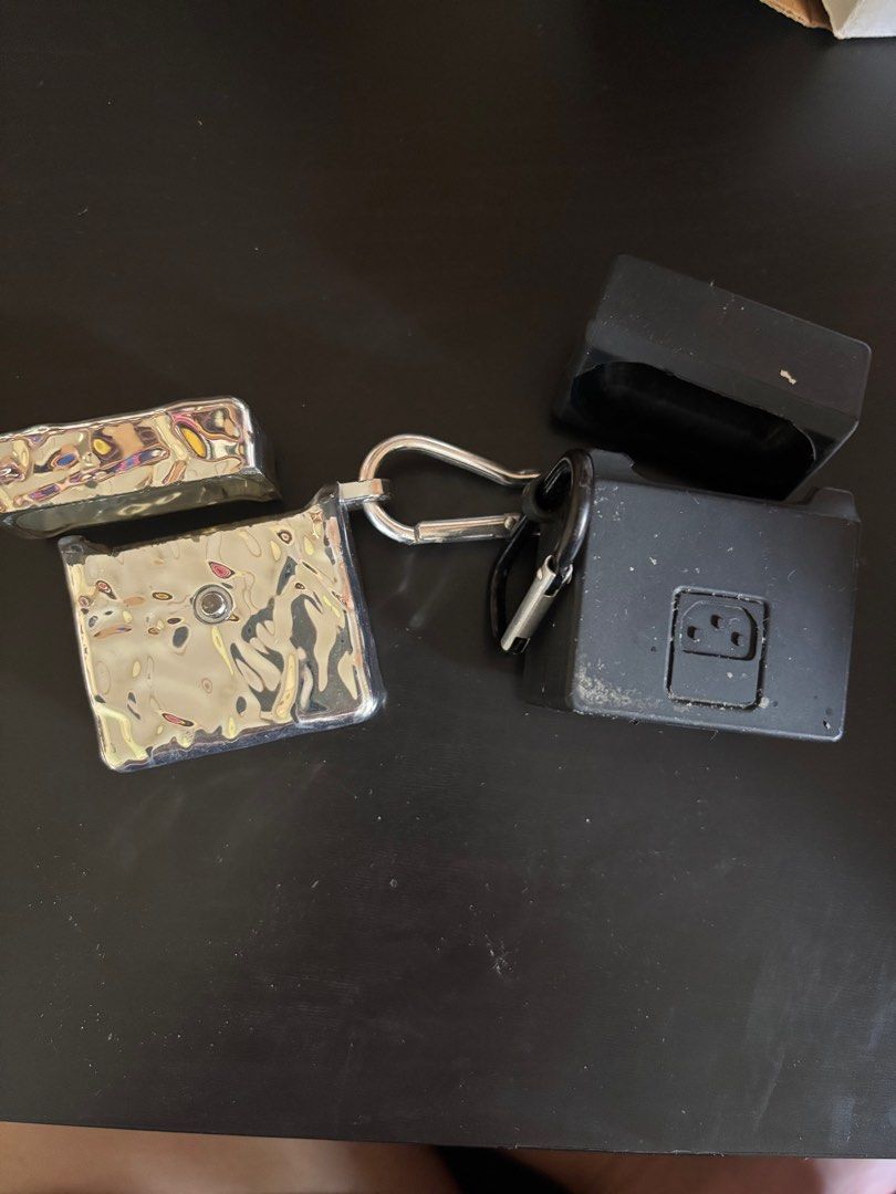 AirPods 2 Cases (2 for PHP200) (Category: Earphones) located in Valenzuela. Submitted by popyard (Listing ID 1410933233, Image 2). Description: PHP200.00 for both cases! - Unique AirPods cases available: - Marshall amplifier design: Black with gold knobs and logo. - Silver case: Textured, metallic finish. - Both cases include a carabiner clip. - Designed to protect your AirPods..