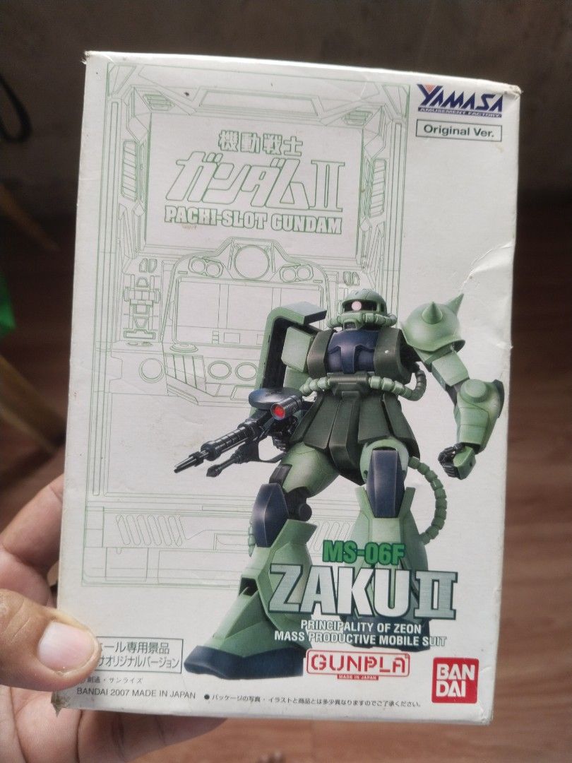 Bandai MS-06F Zaku II Gunpla Model Kit (Category: Gundam & Model Kits) located in Manila. Submitted by megazordbuilderhunter (Listing ID 1410941677, Image 1). Description: - Bandai MS-06F Zaku II Gunpla model kit - Features the iconic Zaku II mobile suit - Includes the Yamasa logo on the box - Contains various green plastic parts, still sealed - From the Pachi Slot Gundam series.