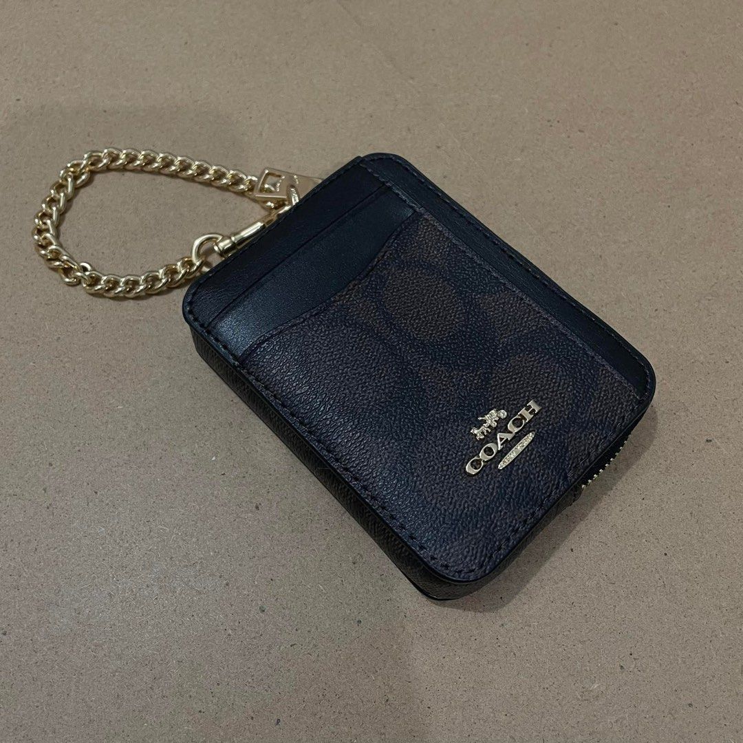 Coach Signature Zip Card Case with Chain (Category: Luxury Bags & Wallets) located in Zamboanga. Submitted by iyodezamboanga (Listing ID 1411001126, Image 1). Description: - Coach card case - Signature brown and black design - Gold chain - Zip closure - Clear ID window - Compact and stylish.