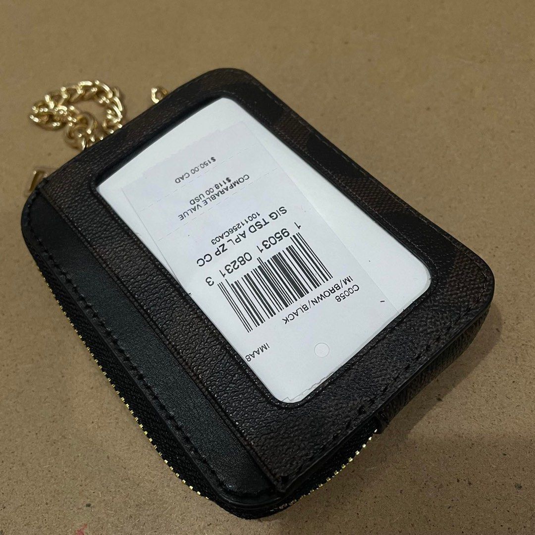 Coach Signature Zip Card Case with Chain (Category: Luxury Bags & Wallets) located in Zamboanga. Submitted by iyodezamboanga (Listing ID 1411001126, Image 2). Description: - Coach card case - Signature brown and black design - Gold chain - Zip closure - Clear ID window - Compact and stylish.