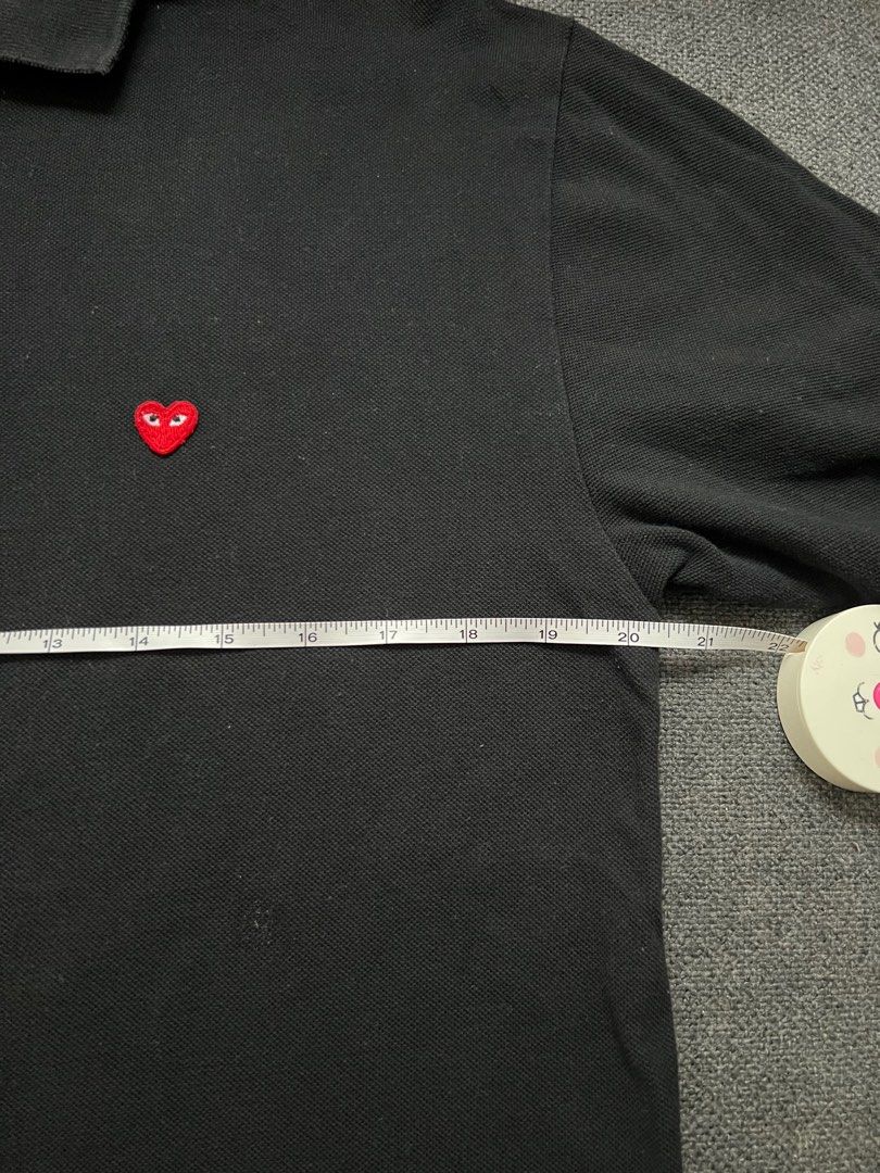 Comme des Garcons Play Black Polo Shirt (Category: Tshirts & Polo Shirts ) located in Quezon City. Submitted by authenticcloset (Listing ID 1410973692, Image 3). Description: Black polo shirt from Comme des Garcons Play. Features the iconic red heart logo on the chest. The shirt has a collared neckline and short sleeves. The shirt is made of a soft material. The shirt has a classic fit. Color rate 8.9/10.
