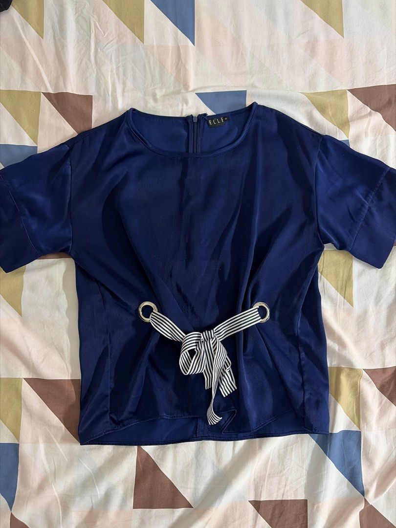 Elle Navy Blue Top with Tie (Category: Sleeveless) located in Cainta. Submitted by _projectsparkjoy (Listing ID 1411000374, Image 1). Description: - Elle navy blue top - Color: Navy blue - Features: - Round neckline - Short sleeves - Back zipper - Waist tie with metal rings - Striped black and white tie detail - Material: Smooth, possibly satin-like.