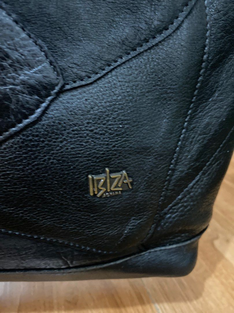 Ibiza Genuine Leather Tote Bag (Category: Tote Bags) located in Quezon City. Submitted by modificabagsph (Listing ID 1410950990, Image 3). Description: Black leather tote bag from Ibiza. Features a zip closure, dual top handles, and decorative tassels. Includes an interior zip pocket and multiple compartments. The bag has a patch design and a metal Ibiza logo. The interior lining is black. The bag has a tag with the Ibiza logo..
