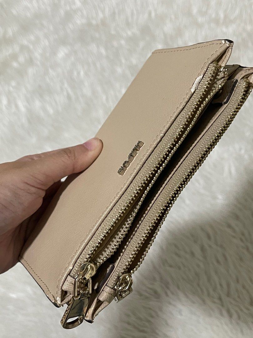 Parfois Beige Wallet (Category: Wallets & Card holders) located in Manila. Submitted by loveditemsbyj (Listing ID 1410941252, Image 2). Description: - Beige Parfois wallet - Multiple compartments for organization - Secure zippered closures - Stylish textured exterior - Includes card slots and clear ID windows - Features metal logo - Shows some wear on the edges.