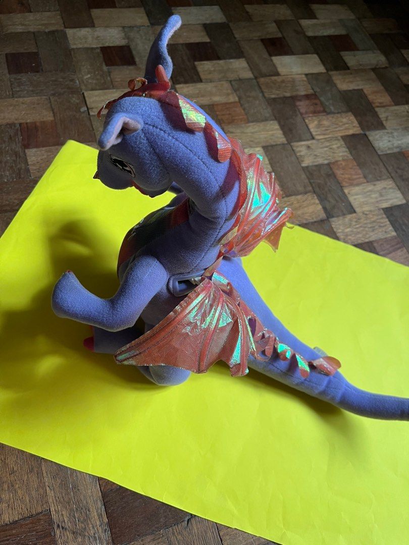 Barbie Rapunzel Penelope Dragon Plush (Category: Plushies & Soft Toys) located in Manila. Submitted by fiercedog-9e3043 (Listing ID 1410931636, Image 3). Description: Penelope Dragon Plush from Barbie as Rapunzel (Mattel, 2002) -Mechanical wing-flapping feature still working -Can bend tail and tilt head in some angles -No rips no tears no issues -White thread on chest is not due to damage. A “press here” tag was sewn on that area as an instructio