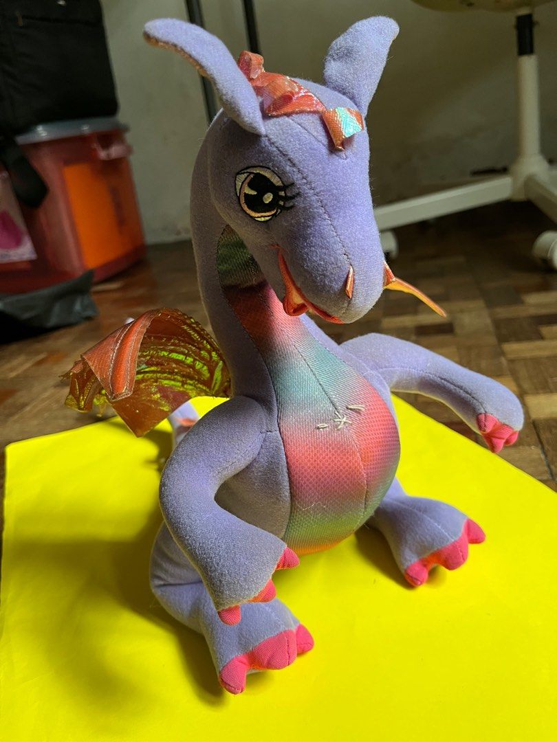 Barbie Rapunzel Penelope Dragon Plush (Category: Plushies & Soft Toys) located in Manila. Submitted by fiercedog-9e3043 (Listing ID 1410931636, Image 2). Description: Penelope Dragon Plush from Barbie as Rapunzel (Mattel, 2002) -Mechanical wing-flapping feature still working -Can bend tail and tilt head in some angles -No rips no tears no issues -White thread on chest is not due to damage. A “press here” tag was sewn on that area as an instructio