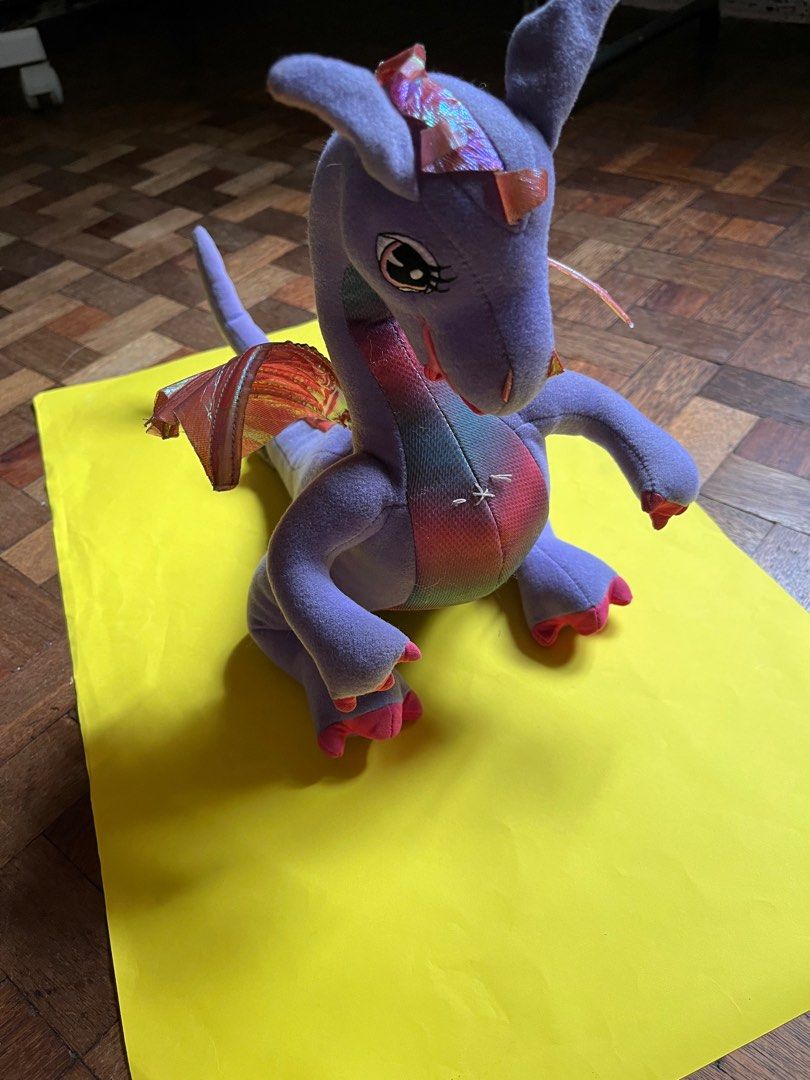Barbie Rapunzel Penelope Dragon Plush (Category: Plushies & Soft Toys) located in Manila. Submitted by fiercedog-9e3043 (Listing ID 1410931636, Image 1). Description: Penelope Dragon Plush from Barbie as Rapunzel (Mattel, 2002) -Mechanical wing-flapping feature still working -Can bend tail and tilt head in some angles -No rips no tears no issues -White thread on chest is not due to damage. A “press here” tag was sewn on that area as an instructio