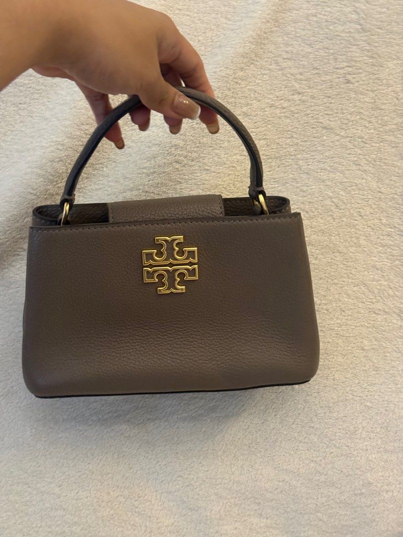 Tory Burch Britten Micro Satchel (Category: Luxury Bags & Wallets) located in Pasay City. Submitted by andreaflo (Listing ID 1410913442, Image 2). Description: • Color: Taupe | Size: OS • Condition: 9.5/10; can pass as brand new!! • top handle bag w/ detachable crossbody strap 👜 • with tags & paper bag; perfect for gifting 🏷️🎁 🇯🇵 bought in Japan.