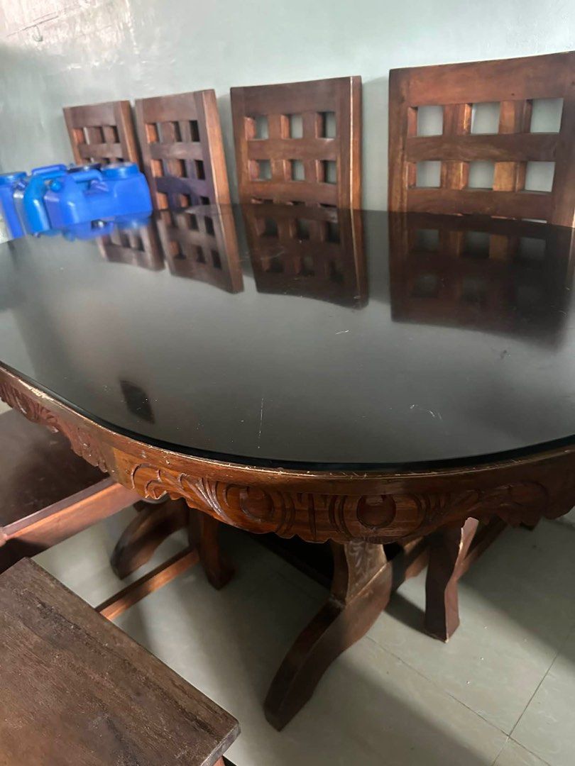 Wooden Dining Table + 6 chairs (Category: Tables & Sets) located in San Pedro. Submitted by rsnchz (Listing ID 1405937322, Image 2). Description: DINING TABLE with Glass top and 6 CHAIRS - Dark-colored oval dining table with glass top - Decorative carved table base - Rich, warm wood tone Issues: scratches Price still negotiable .