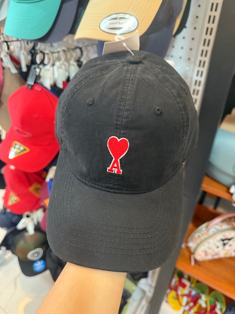 AMI Paris Black Cap (Category: Caps & Hats) located in Lipa City. Submitted by thyra06 (Listing ID 1411206275, Image 1). Description: - AMI Paris black cap - Features the iconic AMI logo - Classic curved brim design - Adjustable strap for a perfect fit - Includes white lining with AMI Paris branding.