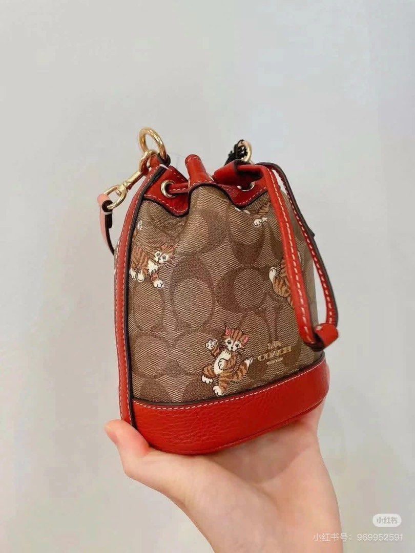 Coach Mini Bucket Bag (Category: Luxury Bags & Wallets) located in Manila. Submitted by jay_cee241623 (Listing ID 1411217689, Image 3). Description: - Coach bucket bag with a playful cat print - Signature Coach canvas - Drawstring closure - Red leather base and trim - Detachable strap - Gold-tone hardware - Includes a Coach hangtag - Stylish and compact design SUPERSALE COACH BAG 🤩 🖇 3,500+ SF 🖇 💯% Authentic & Brandnew 💯% Complete Inclusions
