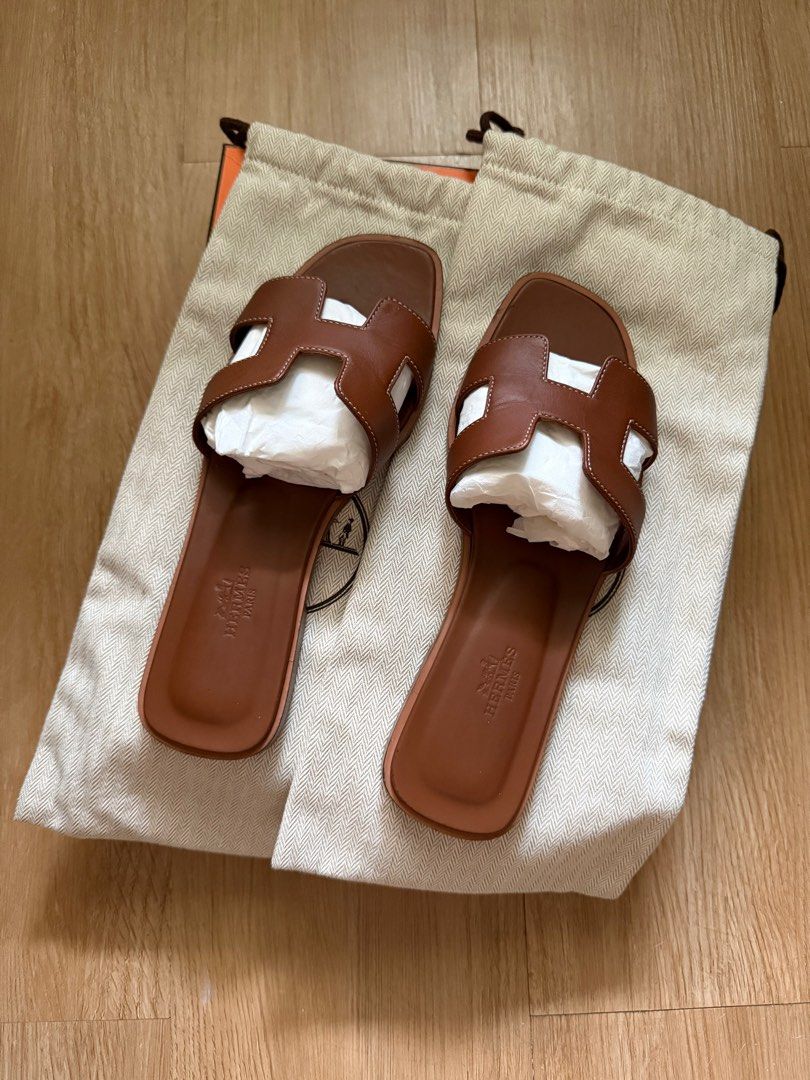 Hermes Oran Sandals in Gold (Category: Sneakers & Footwear) located in Pasig City. Submitted by preloved_pcs (Listing ID 1411153482, Image 2). Description: - Lightly used with only natural signs of wear that are barely noticeable. - Always worn with a sole protector. After removal, the leather sole shows normal signs of use with small pebble impressions from walking, which is common for leather soles and does not affect wear or have structural da