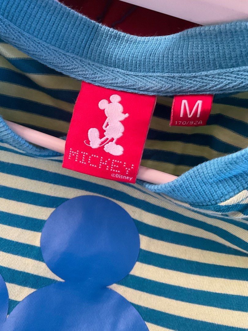 Mickey Mouse Striped T-shirt - Size M (Category: Shirts) located in Manila. Submitted by purpleyamjam (Listing ID 1411082775, Image 2). Description: - Mickey Mouse t-shirt - Size: M - Design: Blue and green striped pattern - Graphic: Large Mickey Mouse on front - Neckline: Round - Sleeves: Short with blue cuffs - Features the Mickey Mouse logo.
